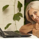 older woman leaning over laptop
