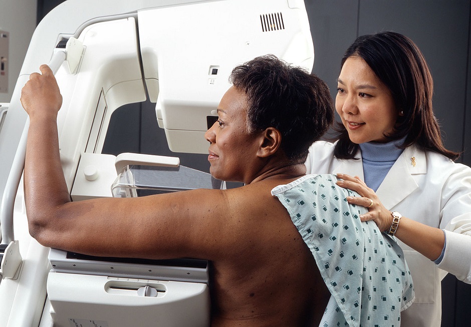 Lady being assisted in a Mammogram by female doctor testing cancer link