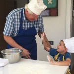 Grandparents cooking with grandchild
