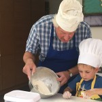 Grandfather cooking with grandchild