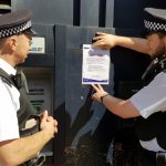 PC Samuel Lowe and PC Brian Masters attaching one of their notices to a local ATM