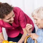 carer giving old lady orange